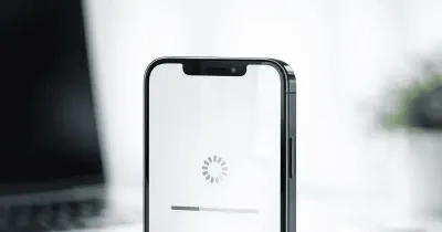 هاتف آيفون يعرض شاشة تحديث iOS 26.2 بواجهة حديثة