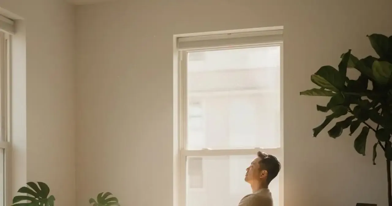 Person sitting calmly in natural light with a notebook, reflecting and practicing mindfulness