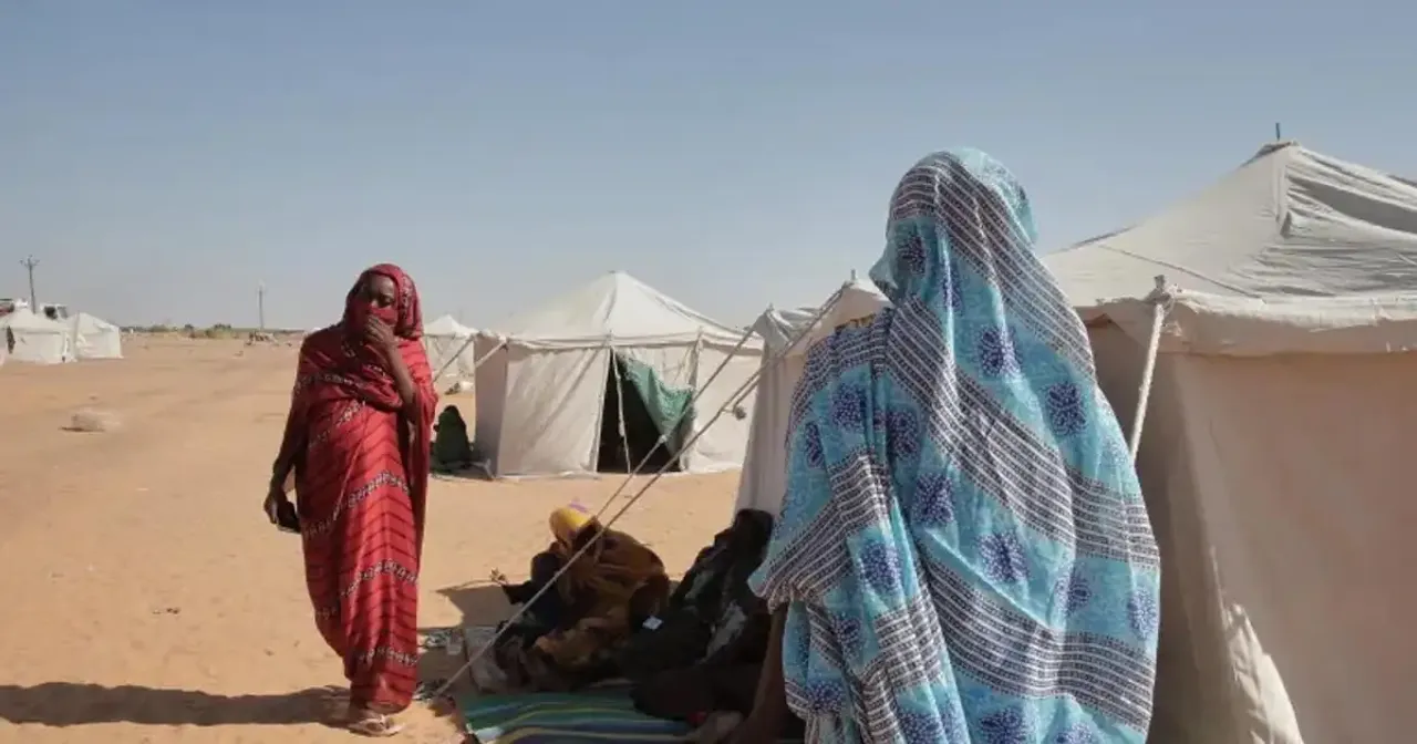 Displaced Sudanese civilians walking toward a growing camp