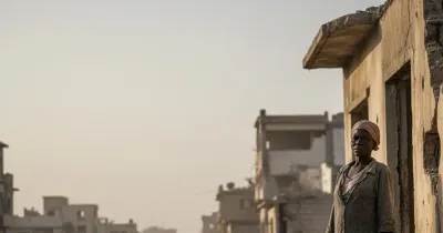 مدني يقف قرب مبانٍ متضررة في الفاشر بالسودان