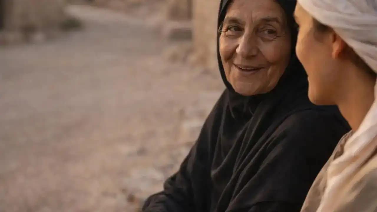 امرأة عربية مسنة تتحدث مع شابة في حي تقليدي